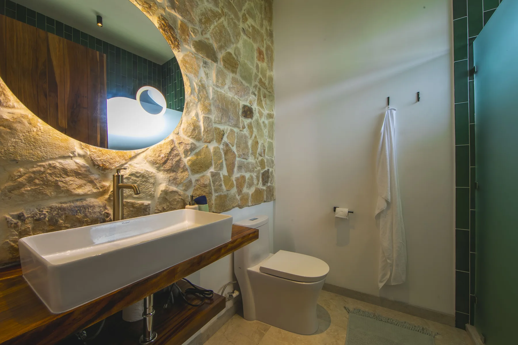 Green tiled ensuite bathroom at Villa Amara